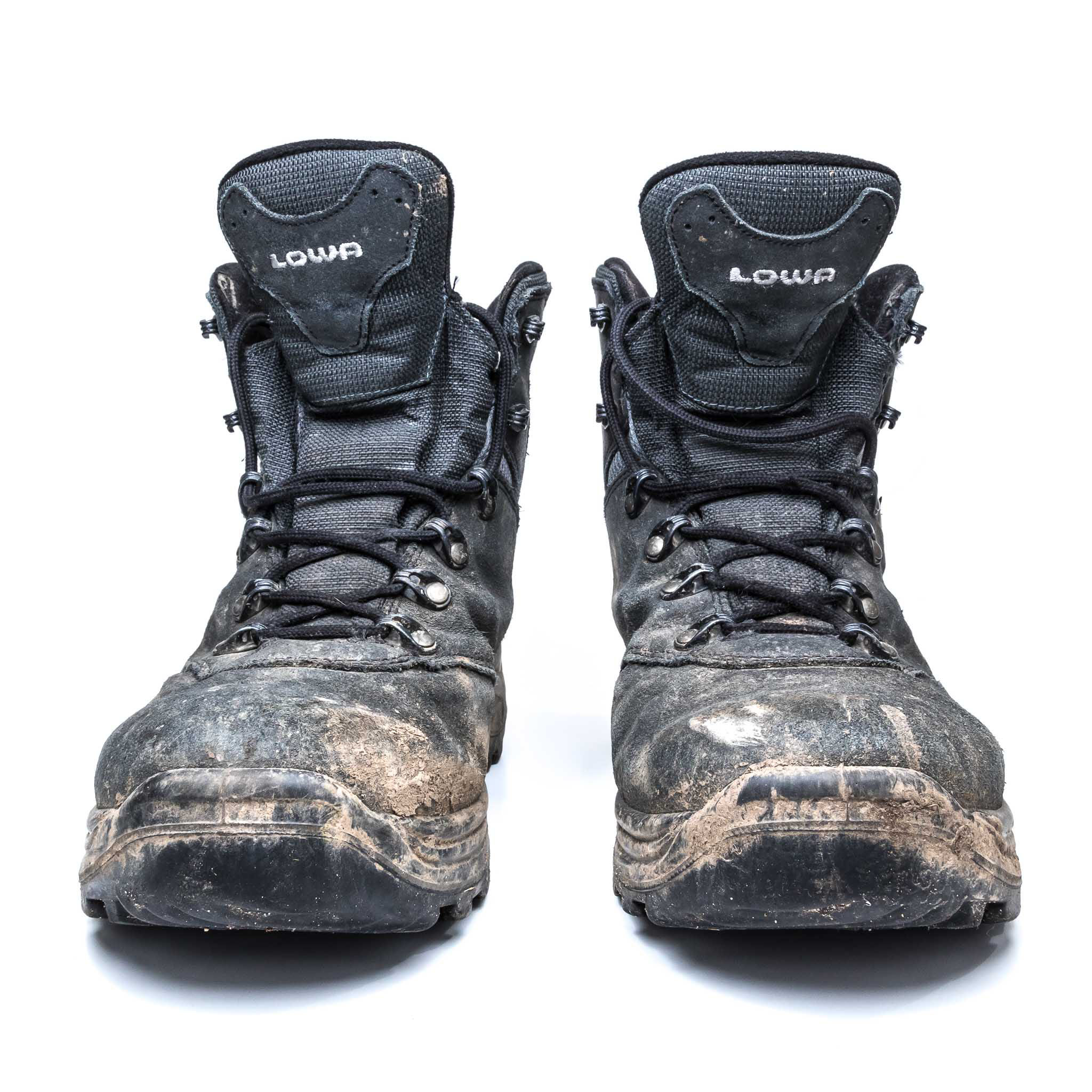 Wanderschuhe Ein Paar stark verschmutzte Wanderschuhe